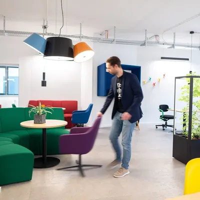 Eine Person verrückt einen Stuhl im Loungebereich im Coworking-Bereich im Coworking Space Rivvers in Mülheim Innenstadt