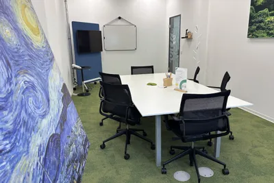 Meetingraum 6 Personen mit Bild auf Staffelei im Vordergrund